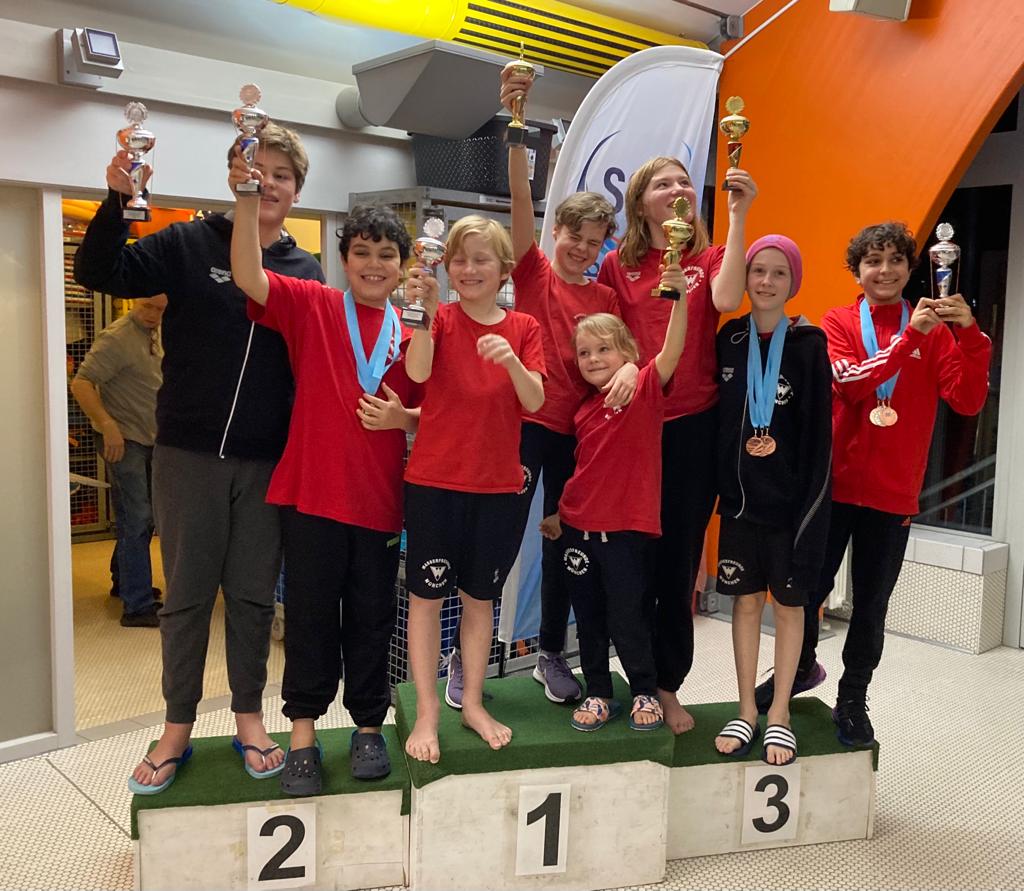 8 Kinder mit Medaillieren und Pokalen